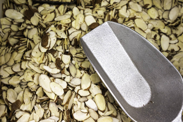 Sliced Almonnd nuts in dispenser with a scoop - Photo, Image