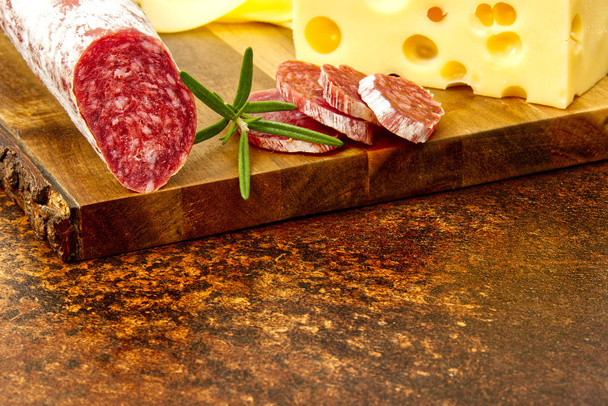 Hús és sajt lemez antipasti snack Prosciutto sonka, parmezán, kék sajt, Cantaloupe dinnye és olajbogyó olíva fa tálalóasztalon sötét kő háttér - Fotó, kép