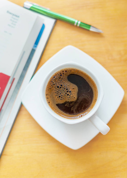 weiße Tasse schwarzen Kaffee auf dem Holztisch. - Foto, Bild