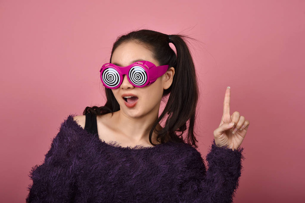 Asian woman hand finger point presenting product for advertising, Happiness girl wearing funny glasses with over exciting wow feeling. - Photo, Image