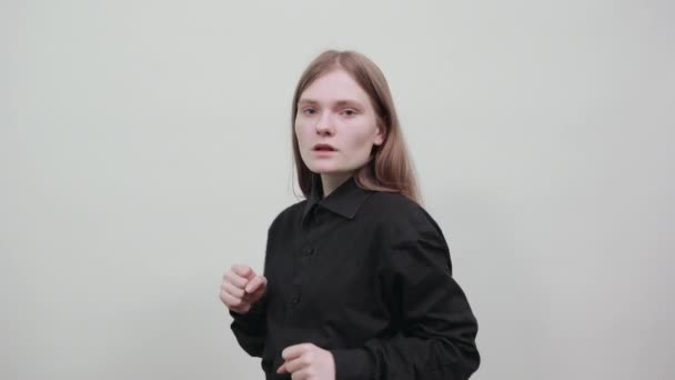Kaukázusi fiatal nő divat fekete ing mutatja ököllel a kamera, harc. - Felvétel, videó