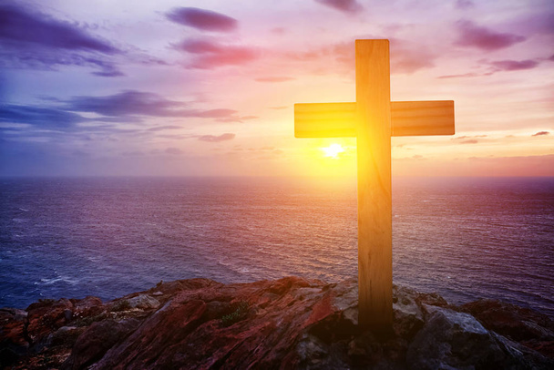 Skála s křesťanským křížem při západu slunce u moře - Fotografie, Obrázek