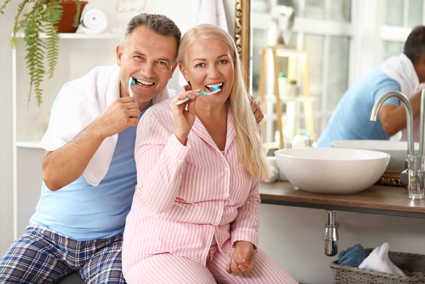 Ώριμο ζευγάρι βουρτσίζει τα δόντια στο σπίτι - Φωτογραφία, εικόνα