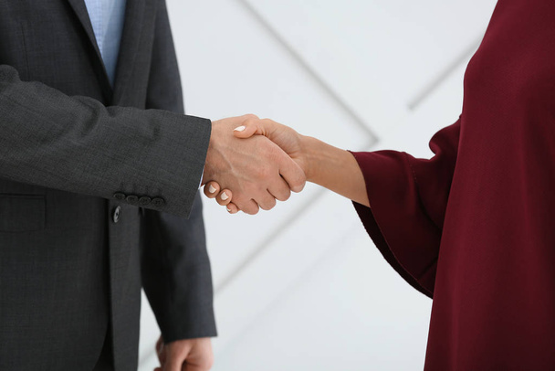 Young business people shaking hands on grey background - Foto, Imagem