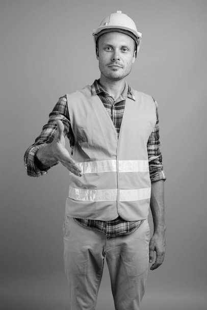 Handsome man construction worker against gray background - Photo, Image