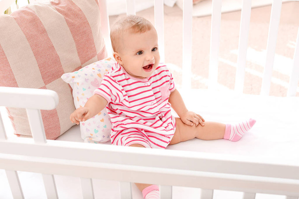 Portrait of cute little baby in crib at home - Фото, зображення