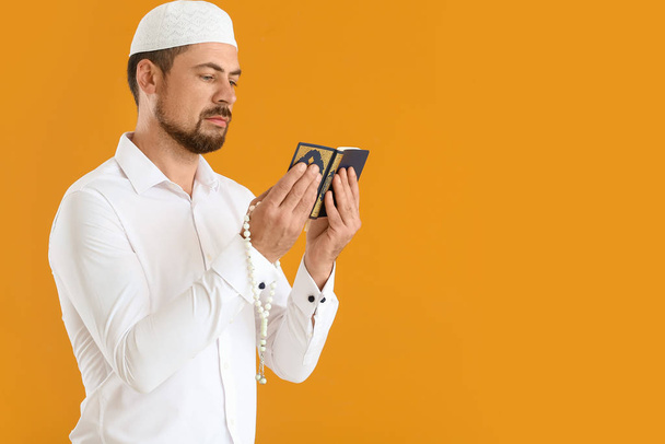 Hombre musulmán con Corán y cuentas en el fondo de color
 - Foto, imagen