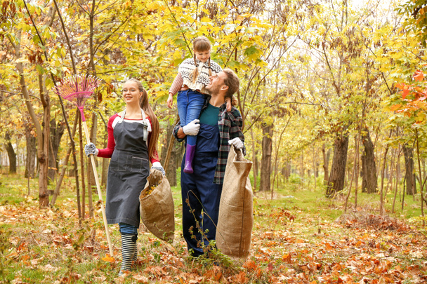 Familie räumt Herbstlaub im Freien auf - Foto, Bild