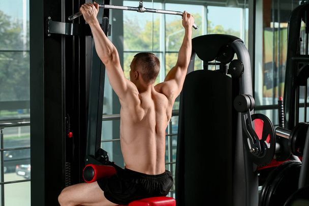 Sporty muscular man training in gym - Фото, зображення