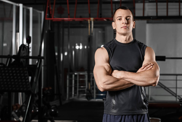 Sporty muscular man in gym - Фото, изображение