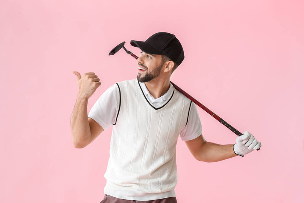 Handsome male golfer pointing at something on color background - Fotoğraf, Görsel