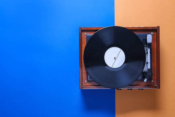 Record player with vinyl disc on color background - Φωτογραφία, εικόνα