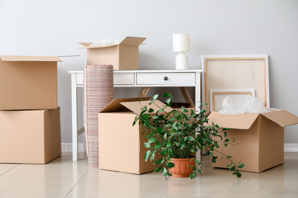 Boîtes en carton avec effets personnels et table dans un appartement neuf le jour du déménagement - Photo, image