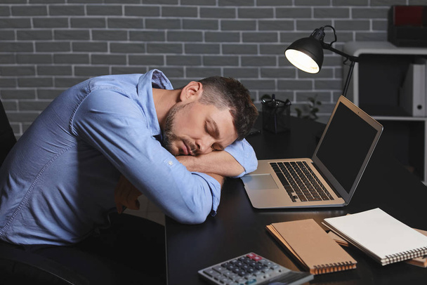 Спящий мужчина в офисе ночью
 - Фото, изображение