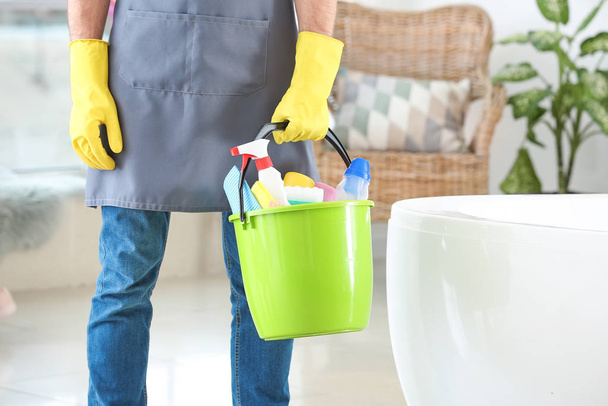 Janitor with cleaning supplies in bathroom - Photo, Image