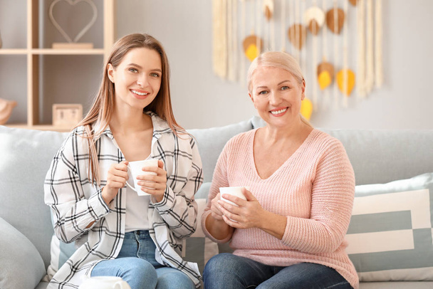 Mature woman and her adult daughter spending time together at home - Φωτογραφία, εικόνα