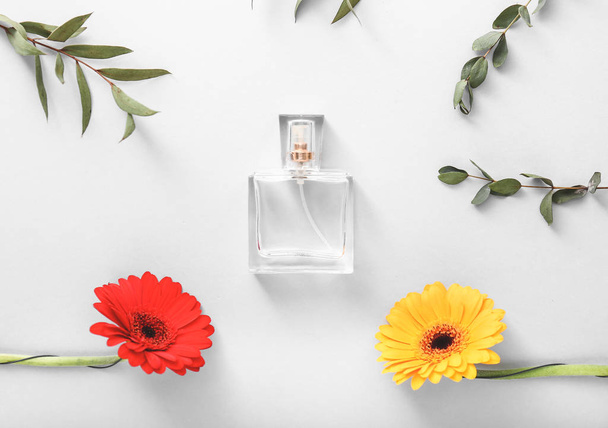 Flasche Parfüm mit Blumen und Blättern auf weißem Hintergrund - Foto, Bild