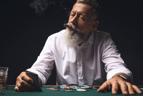 Зрелый бизнесмен играет в казино
 - Фото, изображение