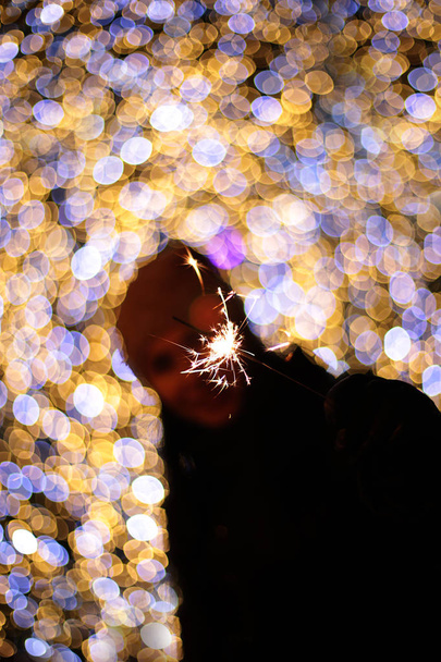 defocused new year macro background garland bokeh different lights colors holiday decor girl with sparkler - Photo, Image