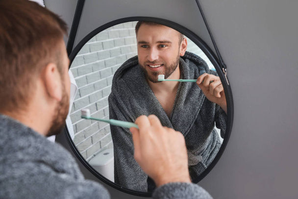 Hezký muž čištění zubů v koupelně - Fotografie, Obrázek