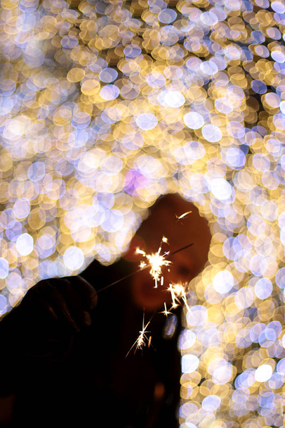 desfocado ano novo macro fundo guirlanda bokeh luzes diferentes cores feriado decoração menina com sparkler
 - Foto, Imagem