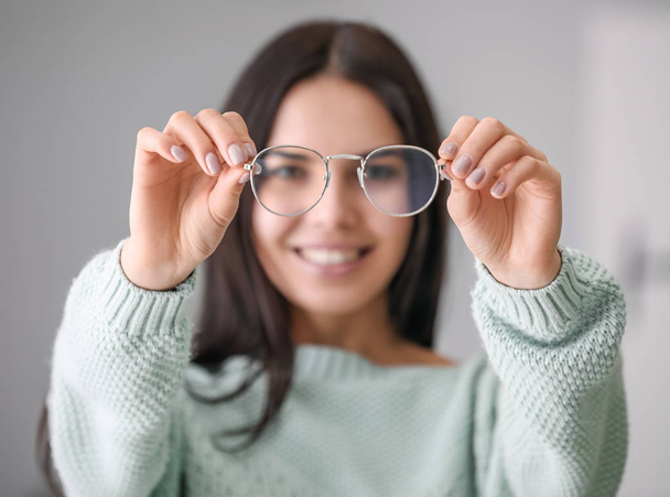 Jovem mulher com óculos elegantes em casa
 - Foto, Imagem