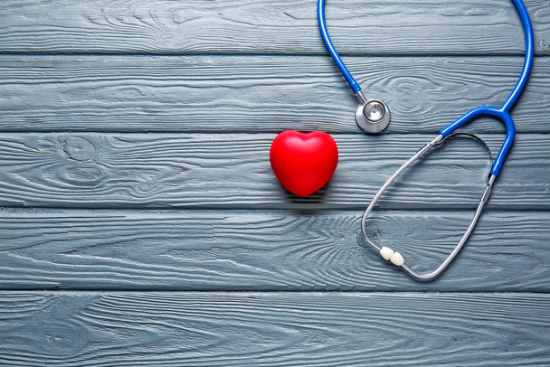 Stethoscope and heart on wooden background - Photo, Image
