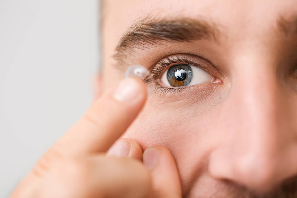 Junger Mann setzt Kontaktlinsen ein, Nahaufnahme - Foto, Bild
