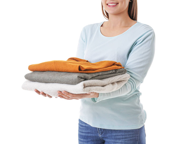 Young woman with clean laundry on white background - 写真・画像