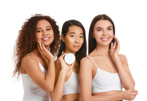 Mooie jonge vrouwen met crème op witte achtergrond - Foto, afbeelding