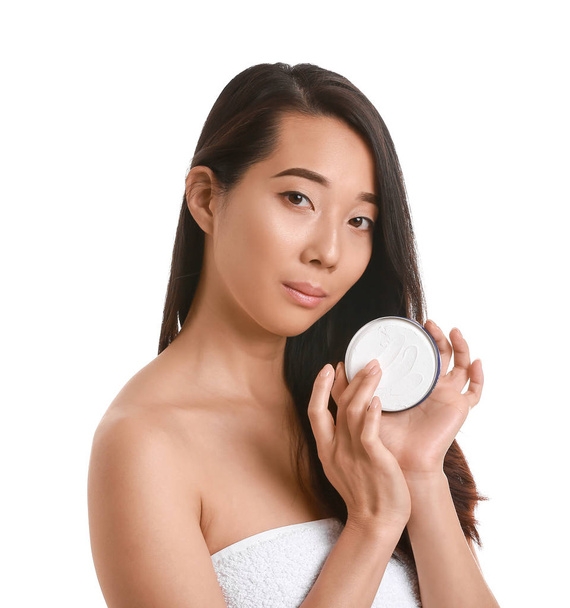 Beautiful young Asian woman with cream on white background - Fotó, kép