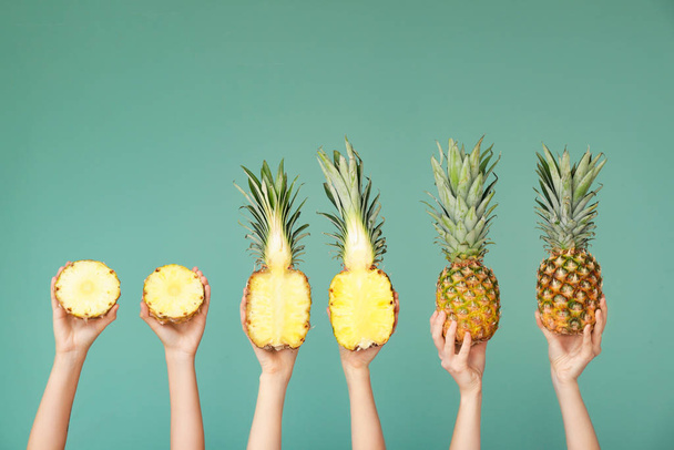 Hands with juicy pineapples on color background - Photo, Image