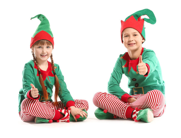 Crianças em traje de elfo mostrando gesto de polegar para cima no fundo branco
 - Foto, Imagem