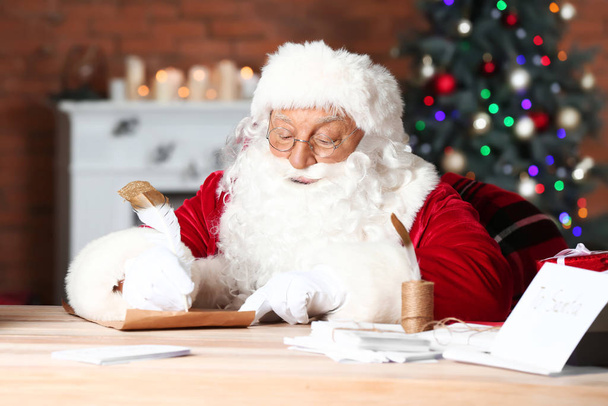 Ο Άγιος Βασίλης κάνει λίστα με δώρα στο δωμάτιο διακοσμημένο για τα Χριστούγεννα - Φωτογραφία, εικόνα