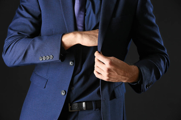 Mężczyzna w stylowych niebieskich ubraniach na ciemnym tle - Zdjęcie, obraz