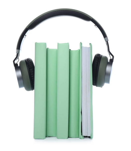 Könyvek és modern fejhallgató fehér háttérrel. Az audiobook fogalma - Fotó, kép