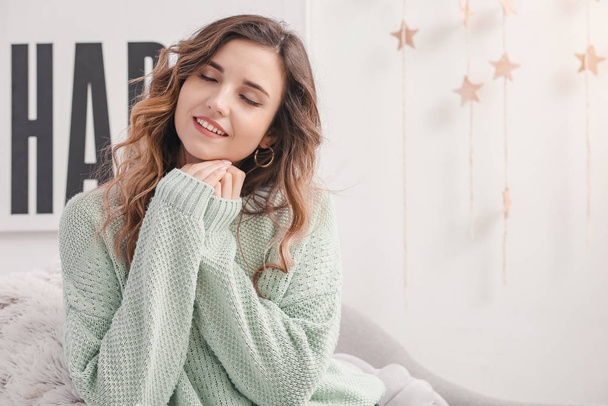 Beautiful young woman in warm sweater at home - Fotoğraf, Görsel