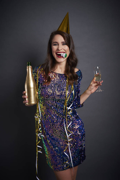 Joyful woman with party hat drinking a champagne - Фото, изображение
