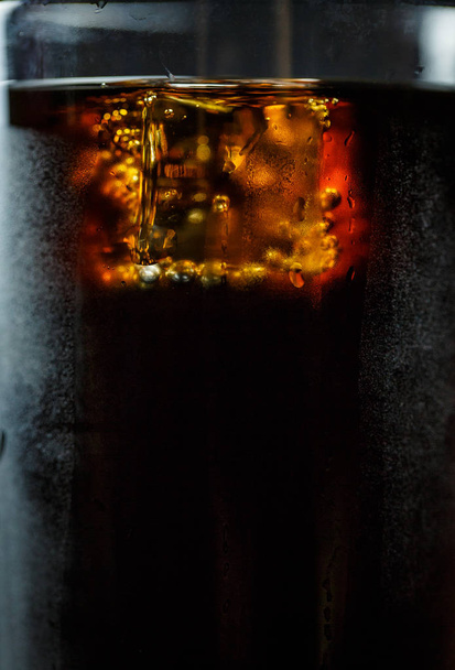 Soda in a glass on a black background with ice cubes and drops - Φωτογραφία, εικόνα