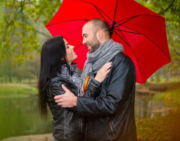 美しい雨の秋の日に屋外の傘で中年のカップルの幸せ - 写真・画像