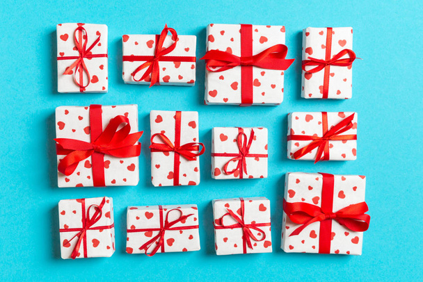 Samenstelling van vakantie witte geschenkdozen met rode harten op kleurrijke achtergrond. Valentijnsdag concept - Foto, afbeelding