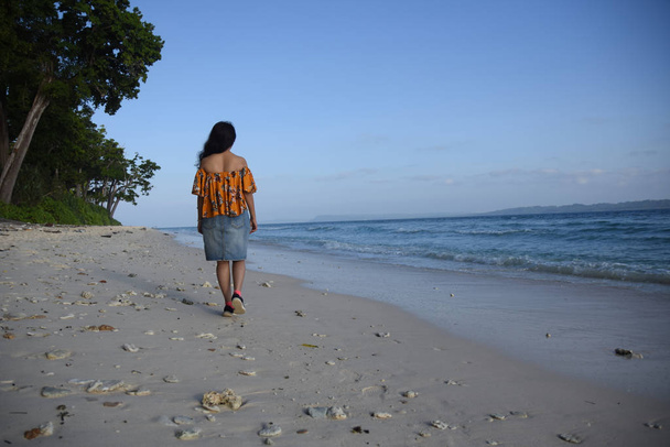 An indian woman tourist walking across beach - Фото, зображення