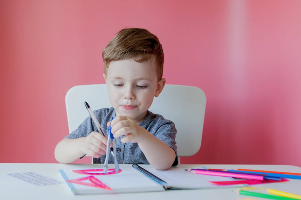 Portrait of cute kid boy at home making homework. Little concent - Фото, изображение