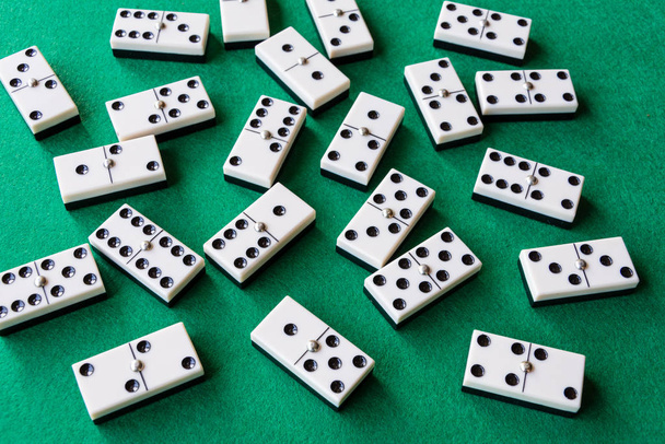 Ansicht von vielen Dominosteinen auf grüner Matte zum Spielen, waagerecht - Foto, Bild