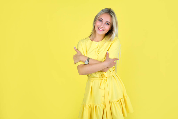 gyönyörű fiatal nő egy sárga ruha sárga háttér - Fotó, kép