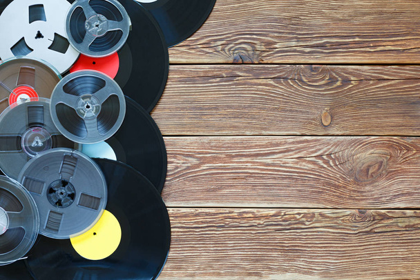 Vieux bobines vintage et disques vinyle sur un fond de table en bois. Étiquettes multicolores. Vue de dessus. Endroit pour copier l'espace
. - Photo, image