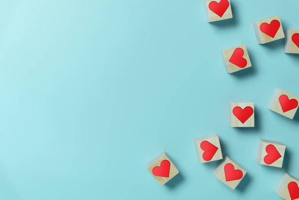 Hearts in Wooden cubes on blue background with copy space. - Foto, Imagen