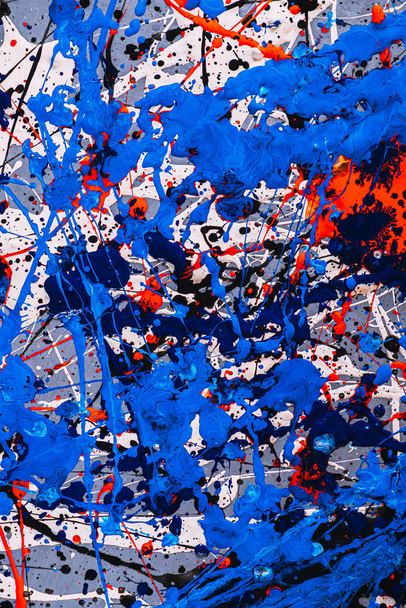 Picture painted using the technique of dripping. Mixing different colors blue red white black. A riot of color. Lines and spots. Vertical orientation. - Photo, Image