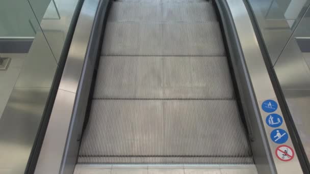 De escadas rolantes estreitas acima que conectam níveis do edifício público moderno
 - Filmagem, Vídeo