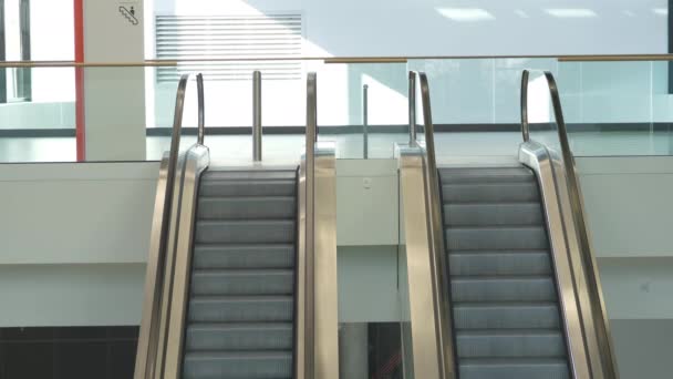 Από πάνω στενές κυλιόμενες σκάλες που συνδέουν τα επίπεδα του σύγχρονου δημόσιου κτιρίου - Πλάνα, βίντεο